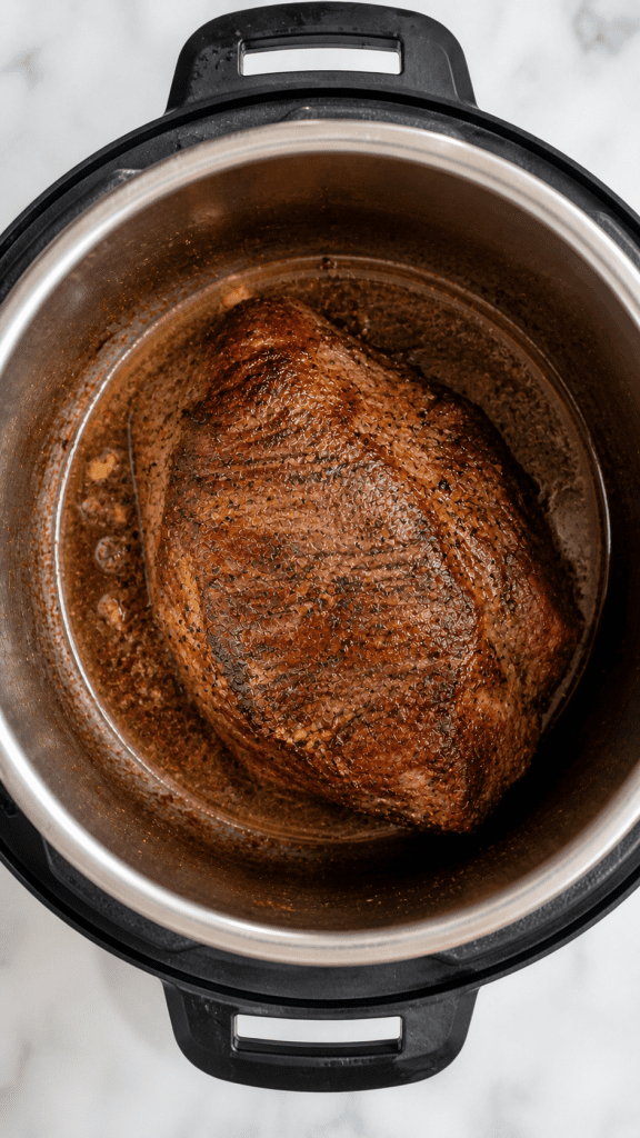 overhead shot of a seared sirloin tip roast in an instant pot